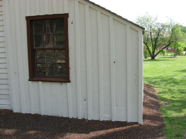 House along stone wall with bullet holes