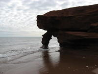 Red sandstone cliffs at Penderosa Beach with tide in (leaning part now gone)